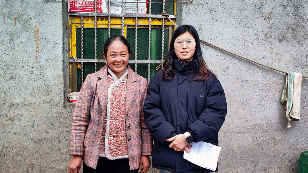 Two women standing together, sharing a moment and looking happy.