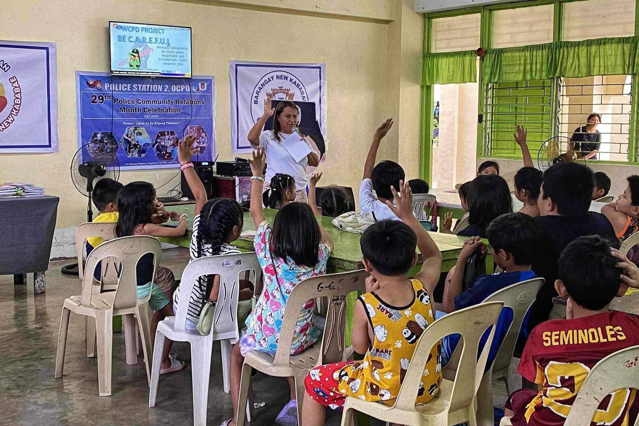 group of children raising hands at a seminar