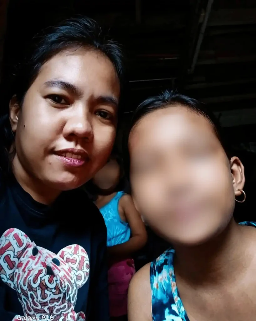 A woman snaps a selfie with her daughter, both looking happy and playful.