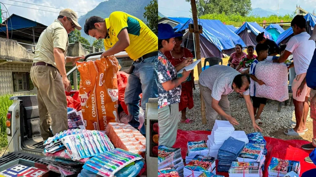Volunteers distribute supplies from a truck bed and tables at an outdoor camp, with people organizing stacks of notebooks, linens, and toiletries.