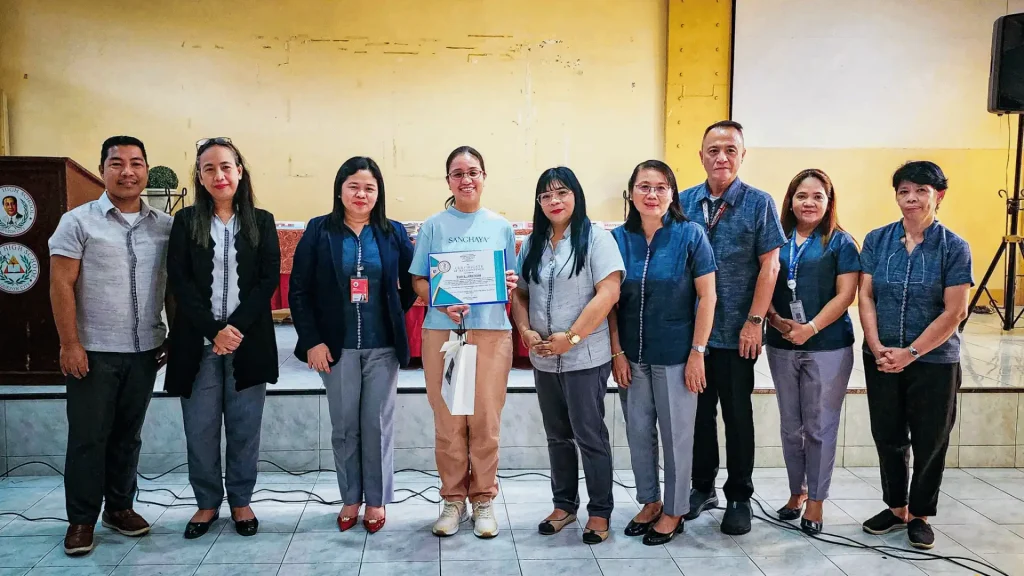  Several individuals stand together, displaying a certificate and sharing smiles in a moment of celebration.
