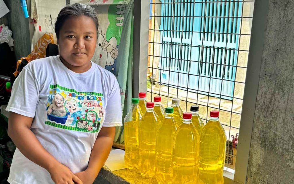 Woman poses with bottles of dishwashing liquids