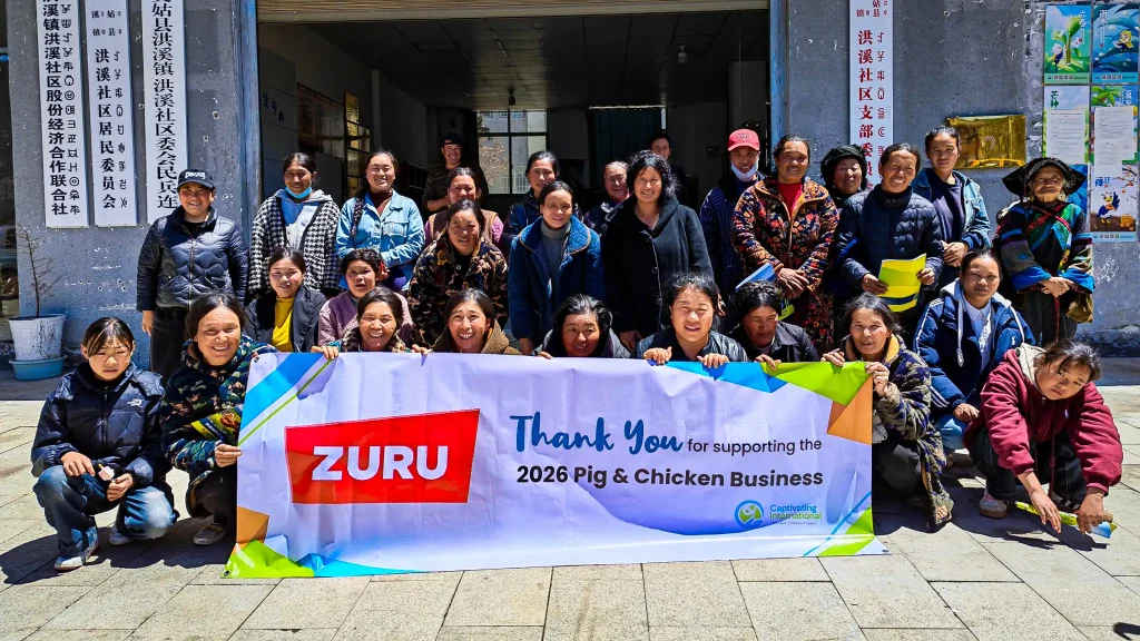 A diverse group of people poses for a photo, proudly displaying a sign that reads "Thank You" in a celebratory environment.