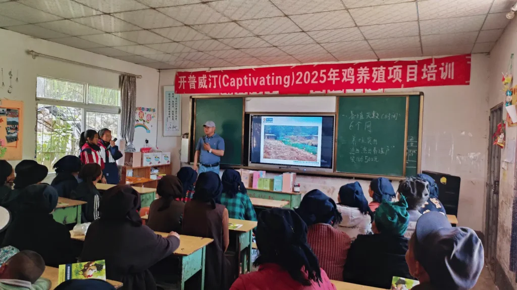 A group of farmers in a classroom, sitting at desks and looking at a screen for a lesson or presentation.