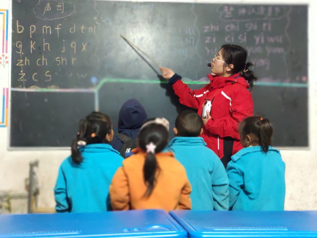 Teacher points something on the blackboard