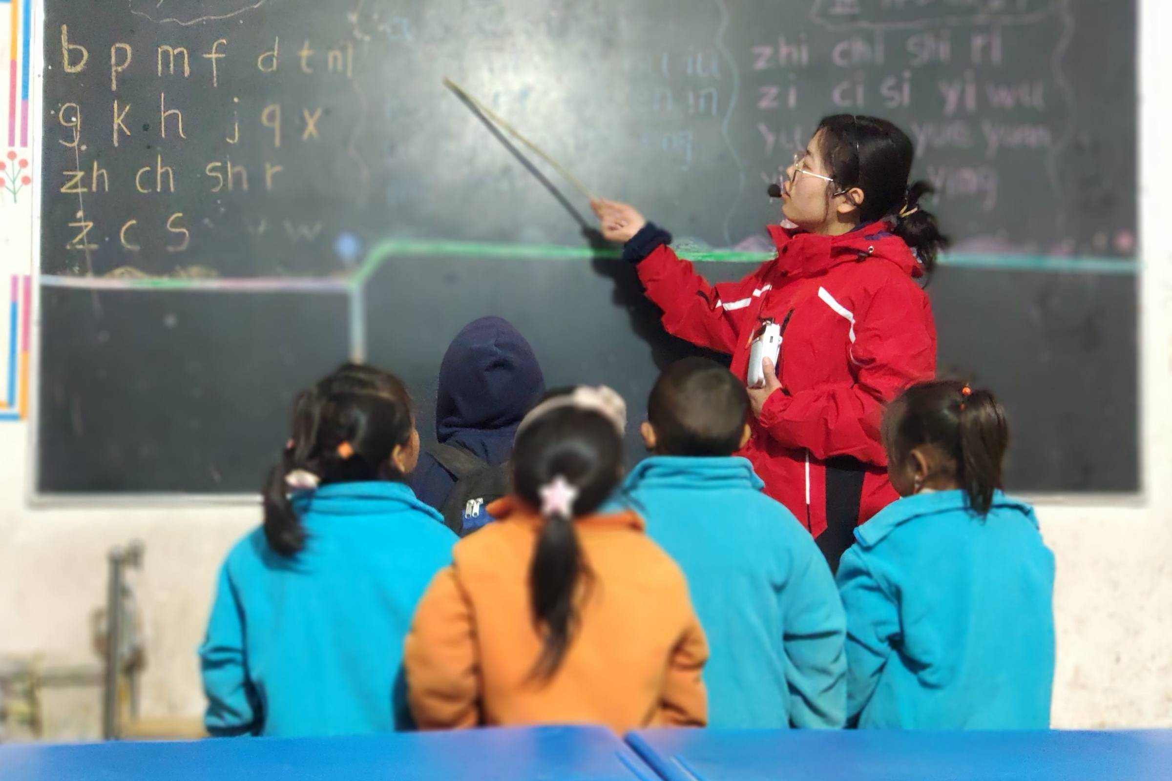 Teacher points something on the blackboard