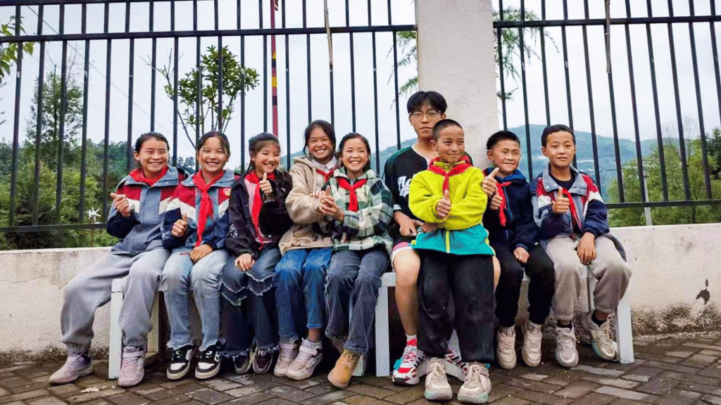 Children gather on a bench with their teacher, sharing laughter and stories in a cheerful atmosphere.