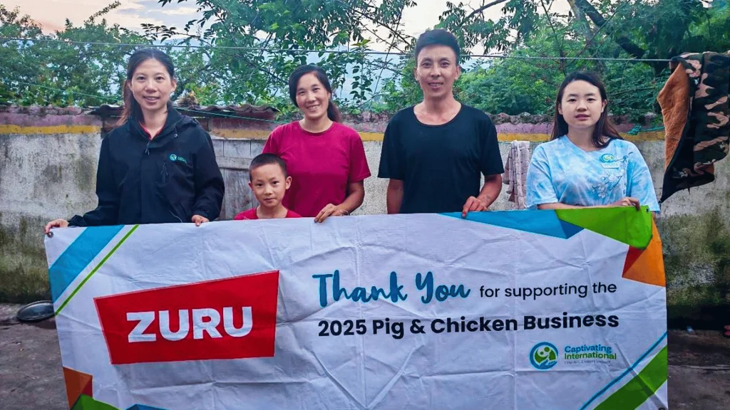 A cheerful group photo of staff with Shenzha and her family.