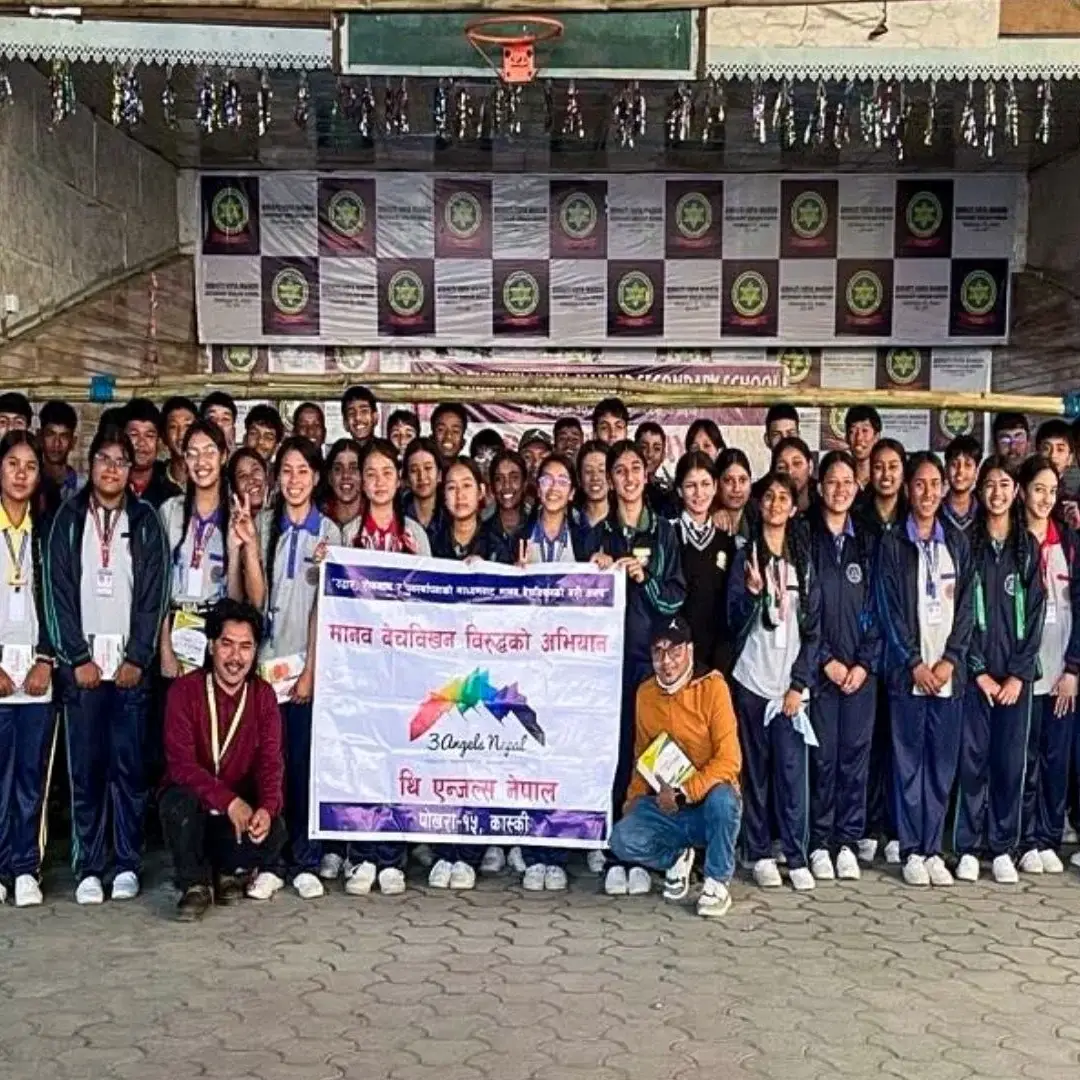 Participants gather for a photo in front of a banner at an anti-human trafficking awareness seminar in Nepal.