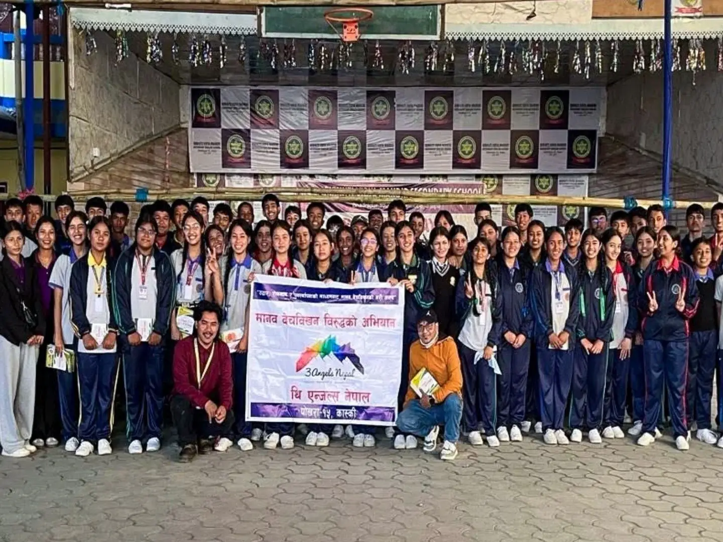 Participants gather for a photo in front of a banner at an anti-human trafficking awareness seminar in Nepal.