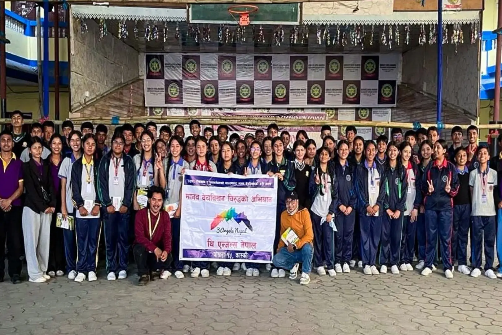 Participants gather for a photo in front of a banner at an anti-human trafficking awareness seminar in Nepal.