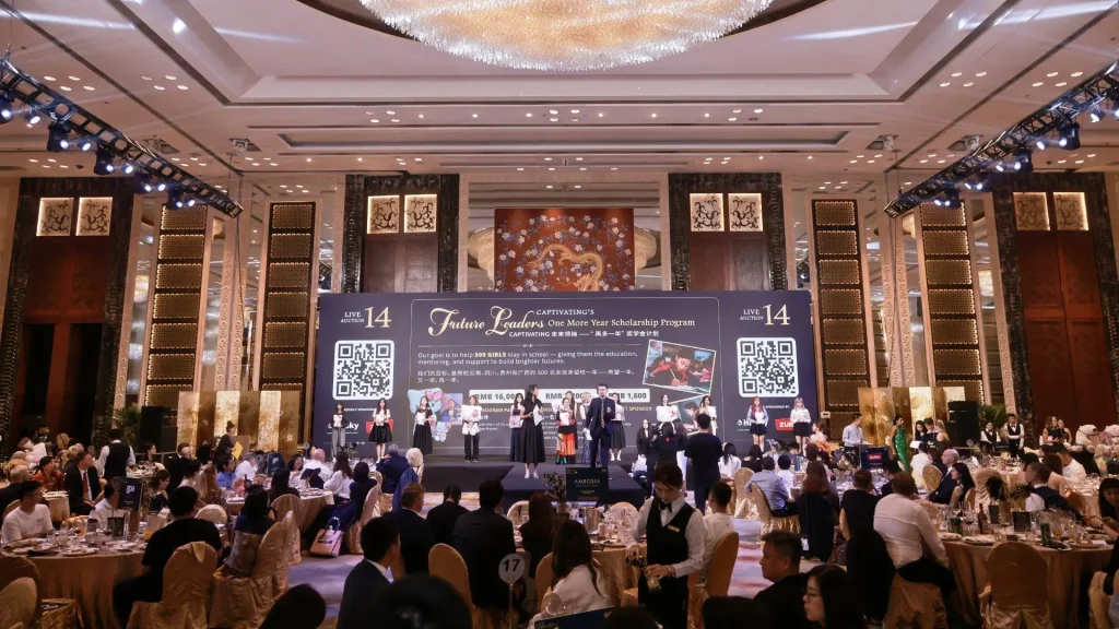 A gala event features a large stage with a banner for the Future Leaders scholarship program, with guests seated at round tables in a ballroom.