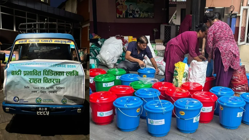 A blue truck with a relief banner parked next to people organizing red and blue plastic buckets filled with supplies for flood relief efforts.